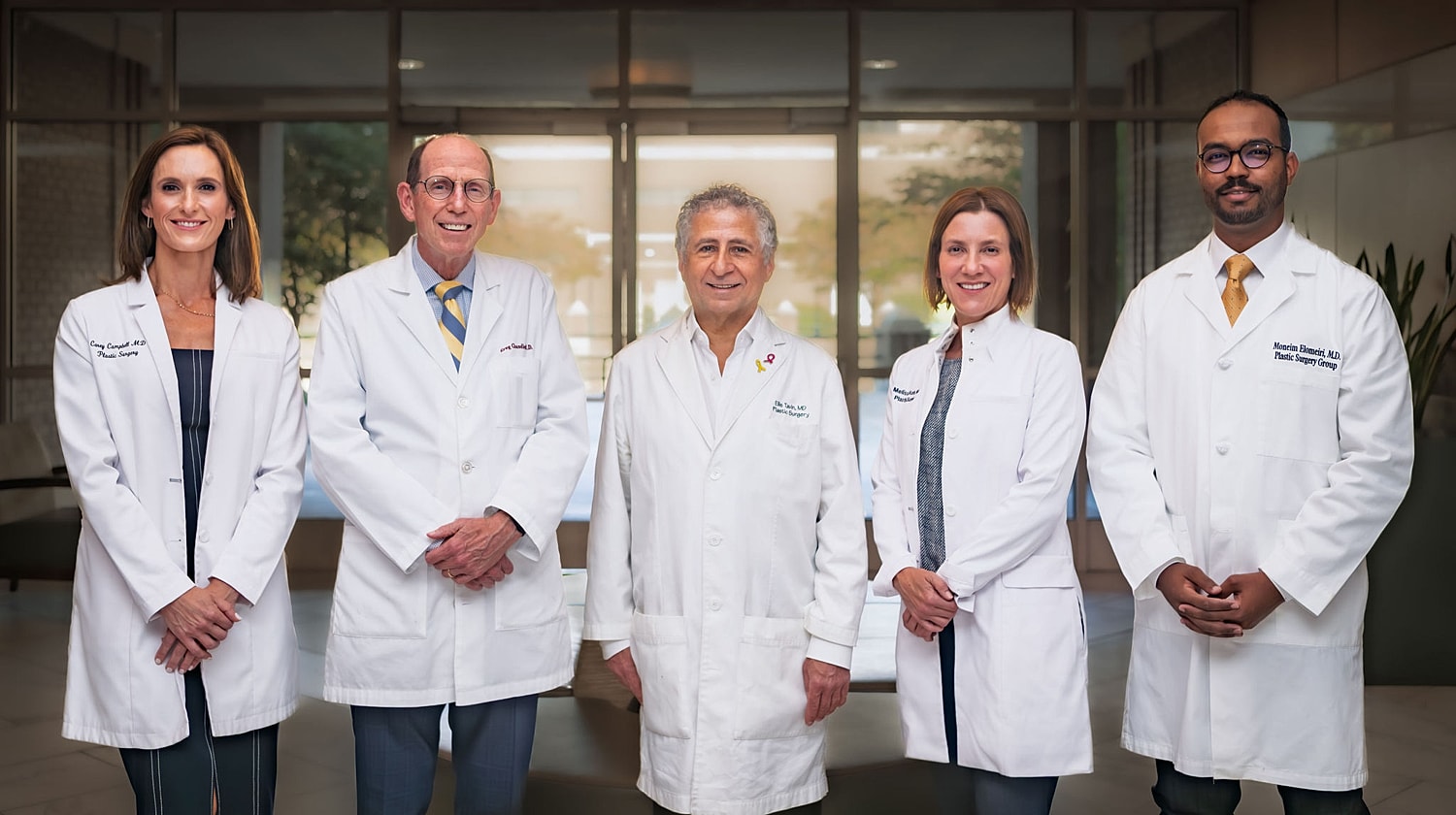 Medical professionals in white coats smiling together.